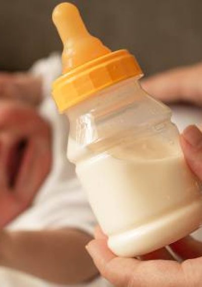 Crying baby with bottle of formula