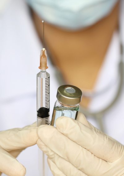 Doctor hand holding draw syringe and medicine bottle on white background