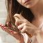 Woman applying chemical hair straightener to her hair